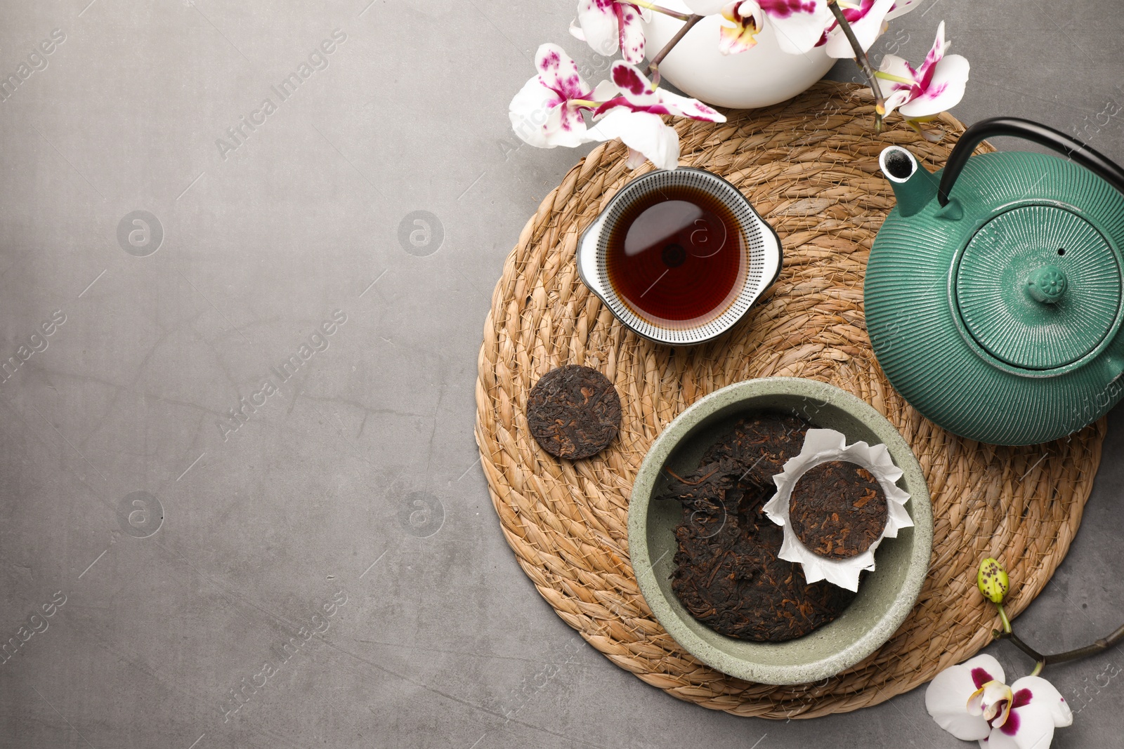 Photo of Flat lay composition with aromatic pu-erh tea on grey table. Space for text