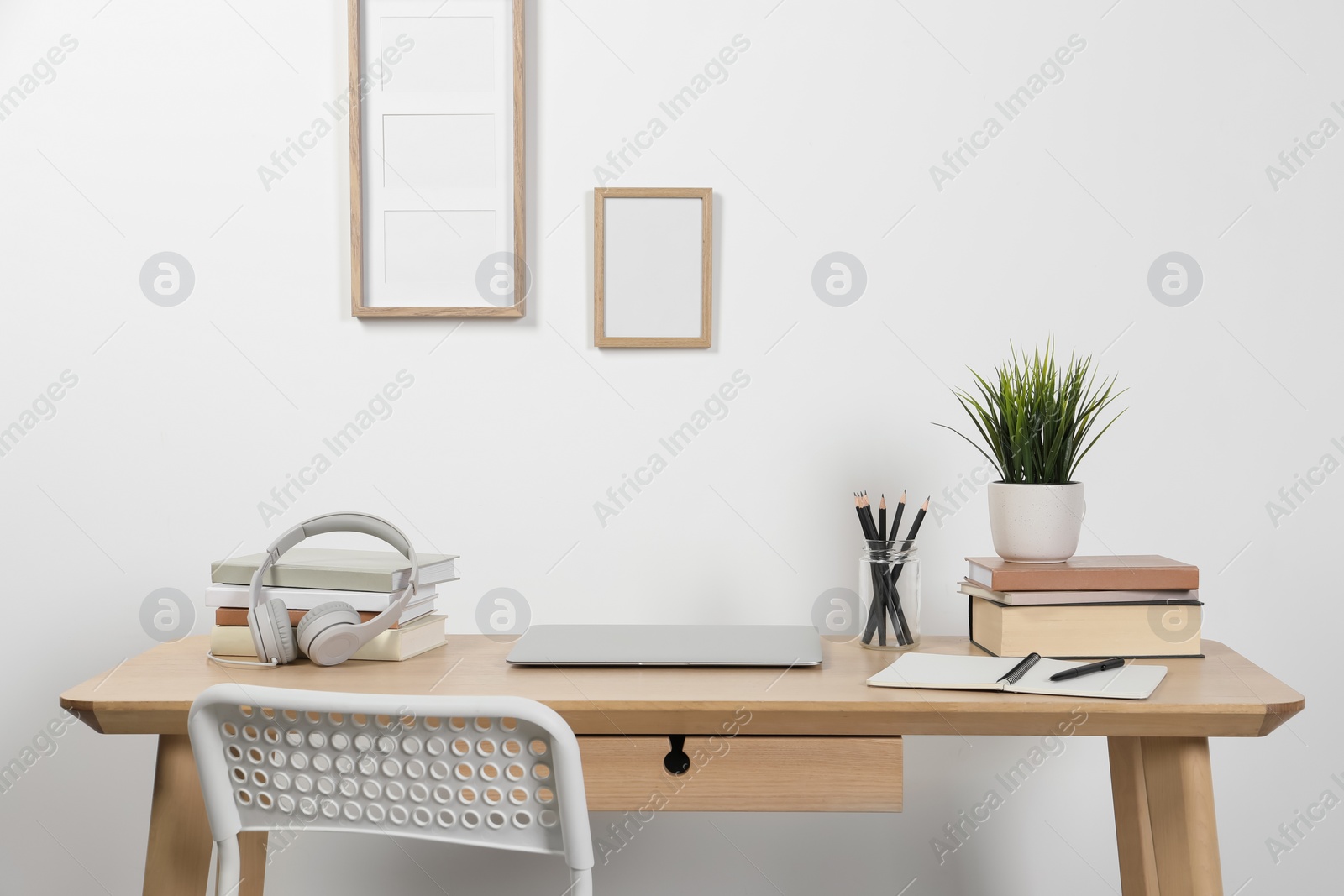 Photo of Cozy workspace with laptop and stationery on wooden desk at home