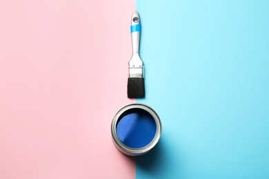 Photo of Open paint can and brush on color background, top view