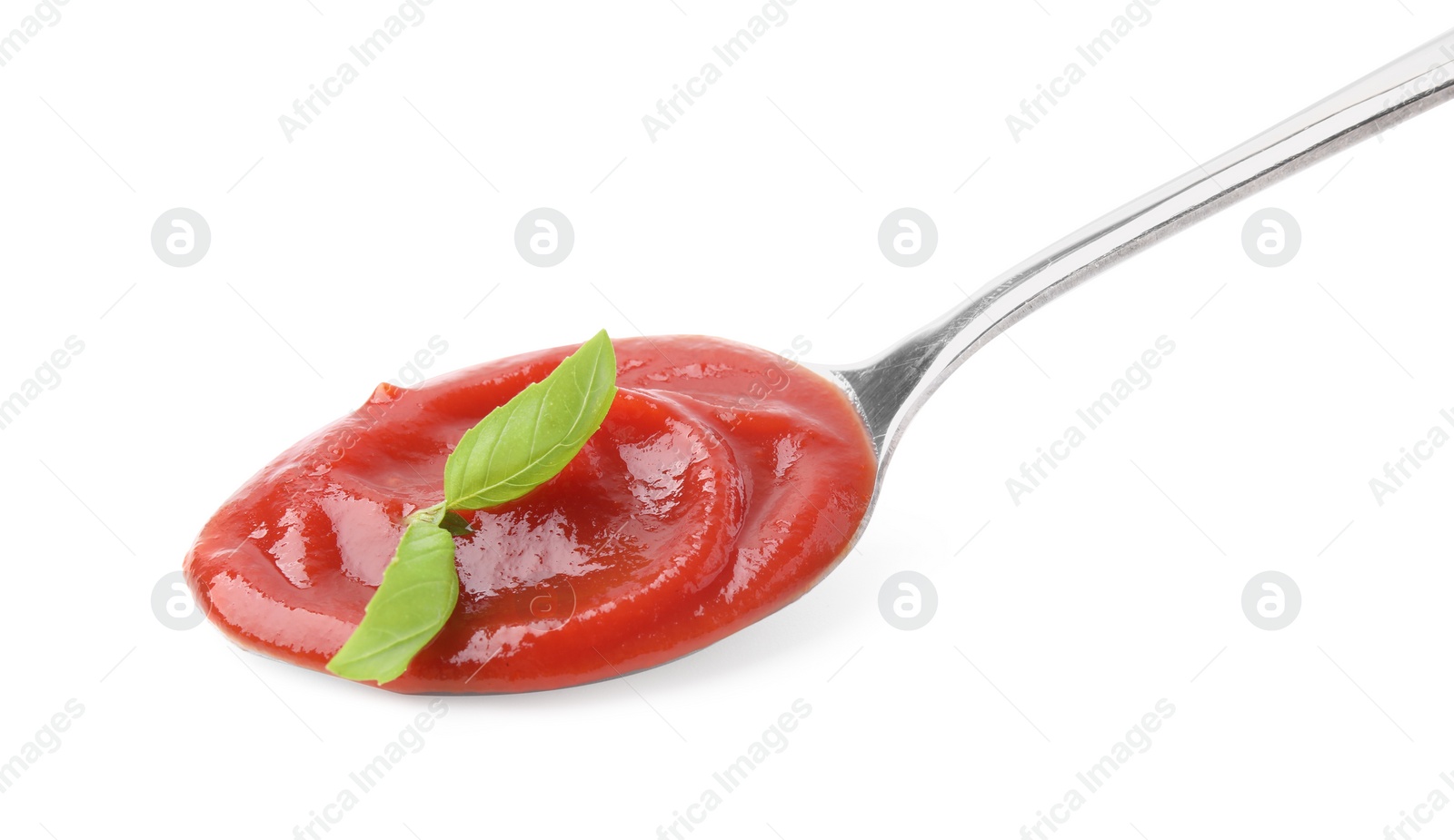 Photo of Spoon with tasty ketchup and basil isolated on white