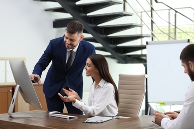 Man helping his colleague with work in office