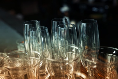 Photo of Different empty clean glasses in bar, closeup