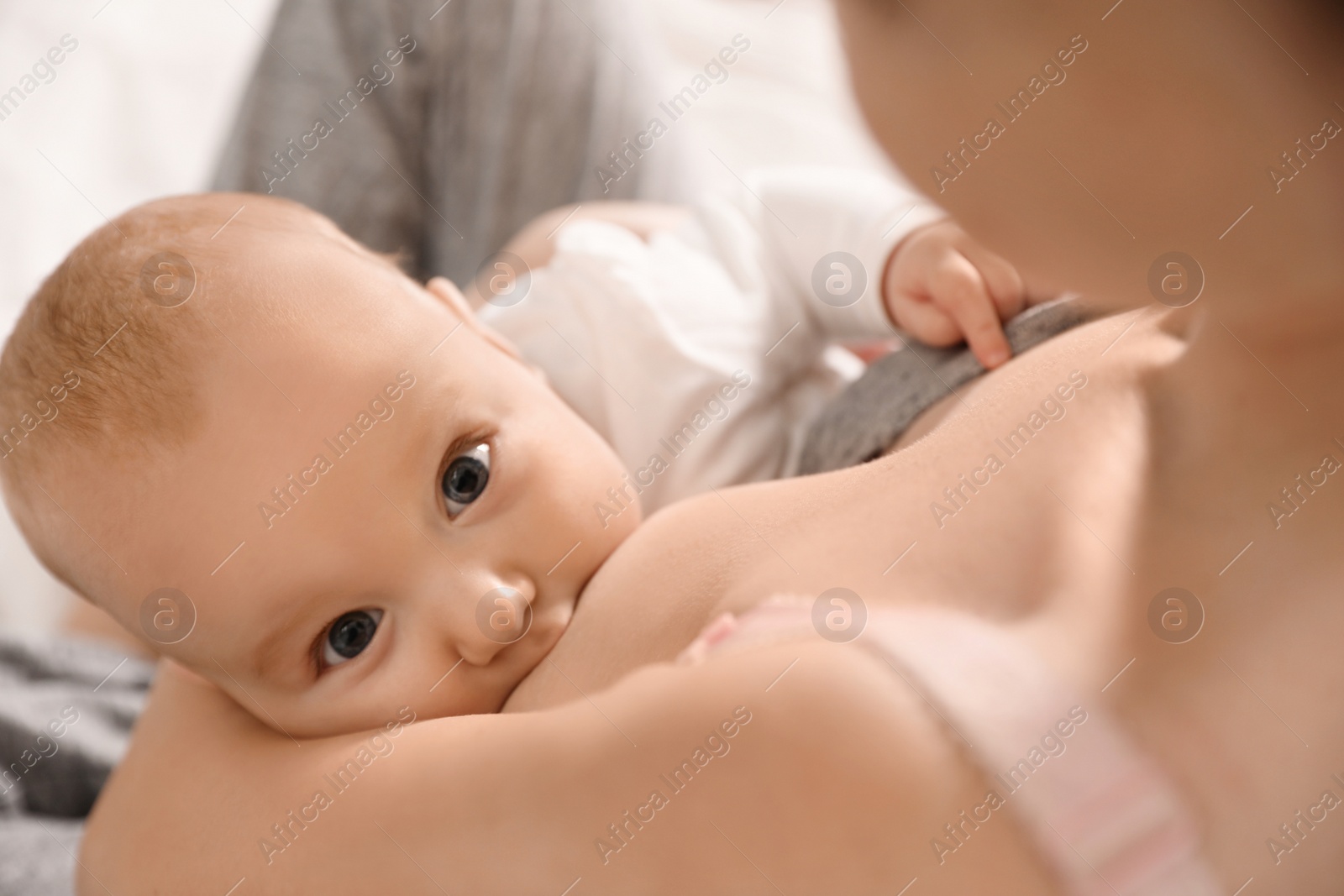 Photo of Young woman breast feeding her little baby, above view