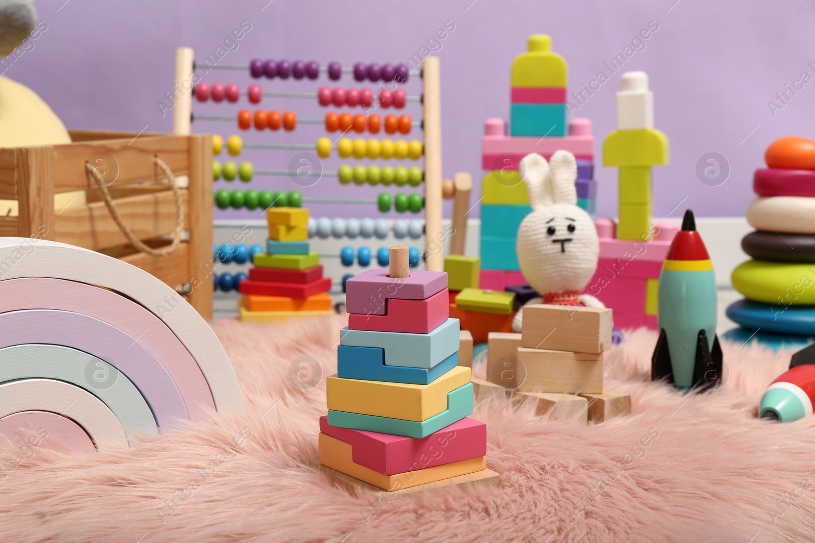 Photo of Set of different toys on rug near violet wall