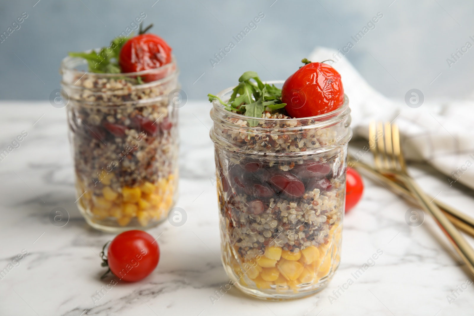 Photo of Jars with healthy quinoa salad and vegetables on table. Space for text