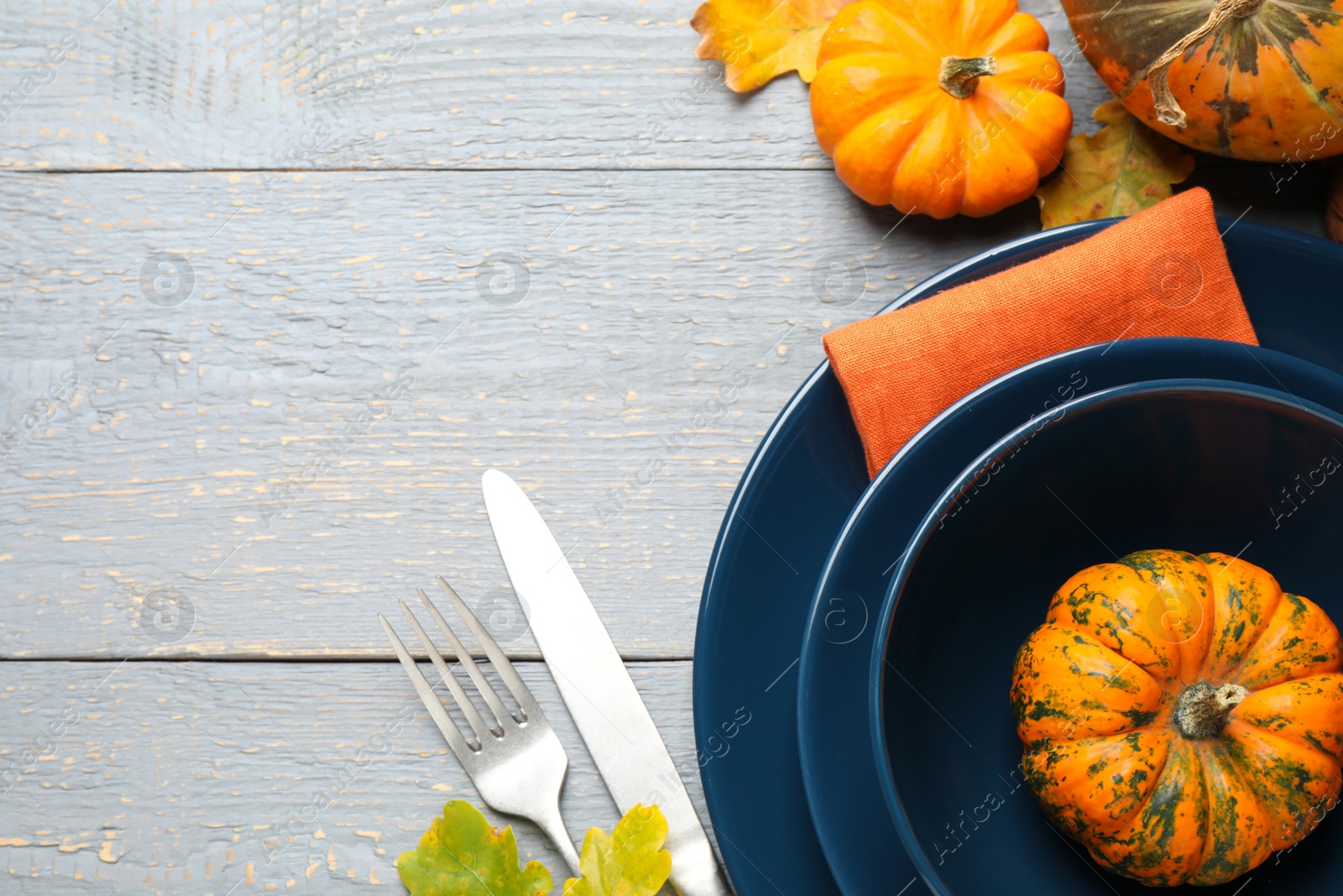 Photo of Festive table setting on light wooden background, flat lay with space for text. Thanksgiving Day celebration