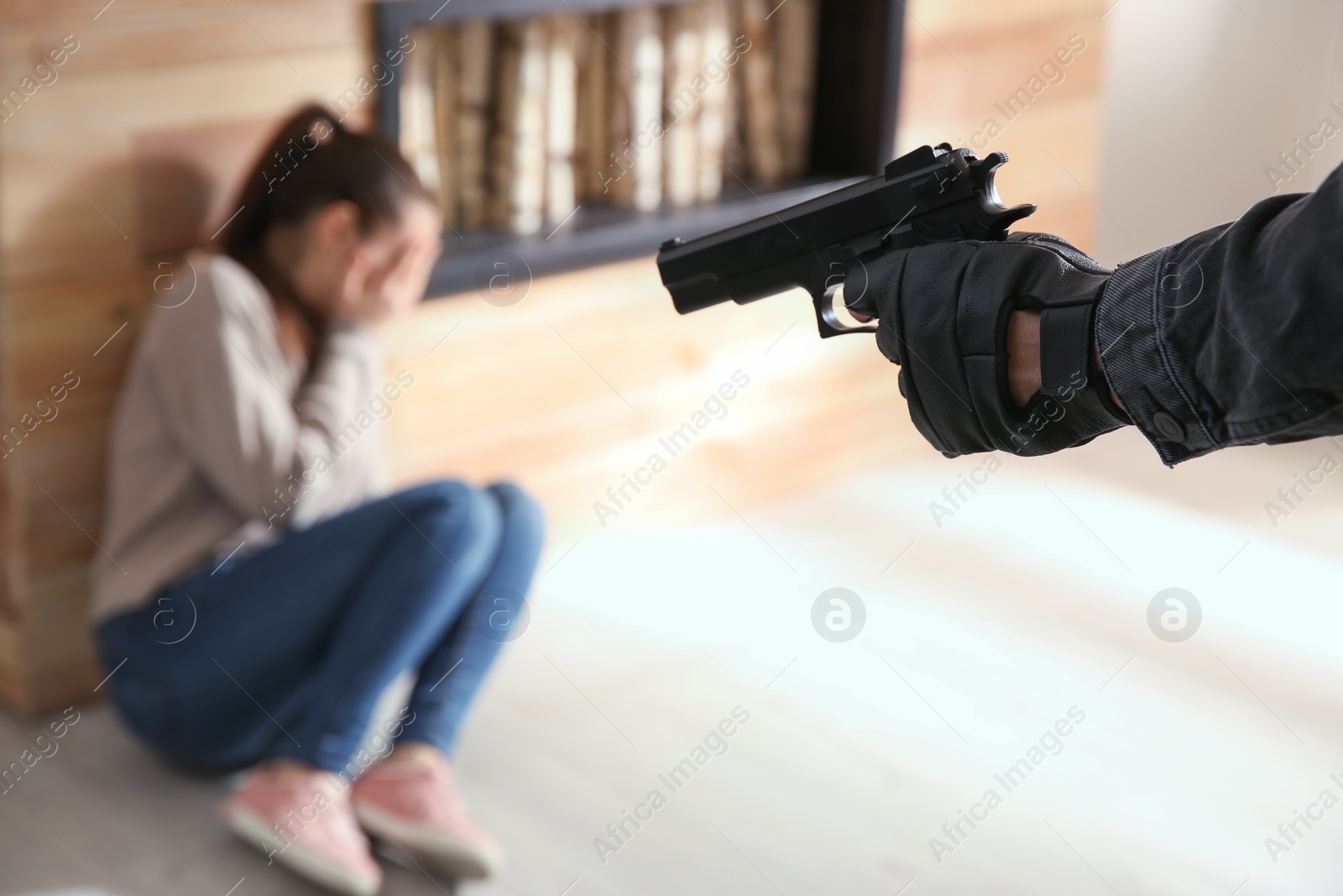 Photo of Man aiming his victim with gun indoors, closeup. Dangerous criminal