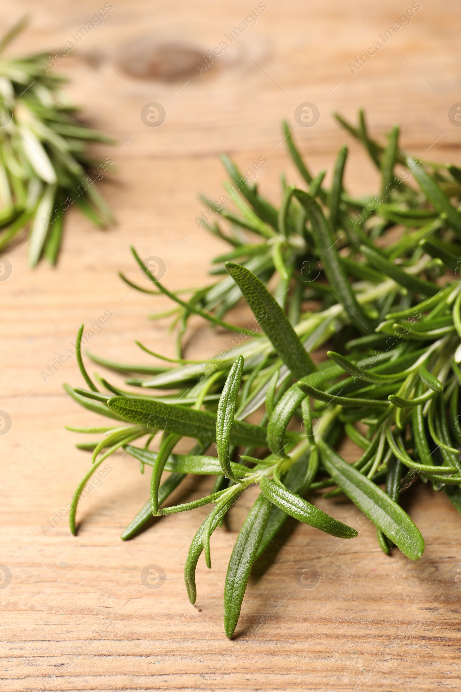 Photo of Fresh green rosemary on wooden table, closeup