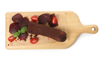 Photo of Delicious dry-cured beef basturma with basil, peppercorns and tomatoes on white background, top view