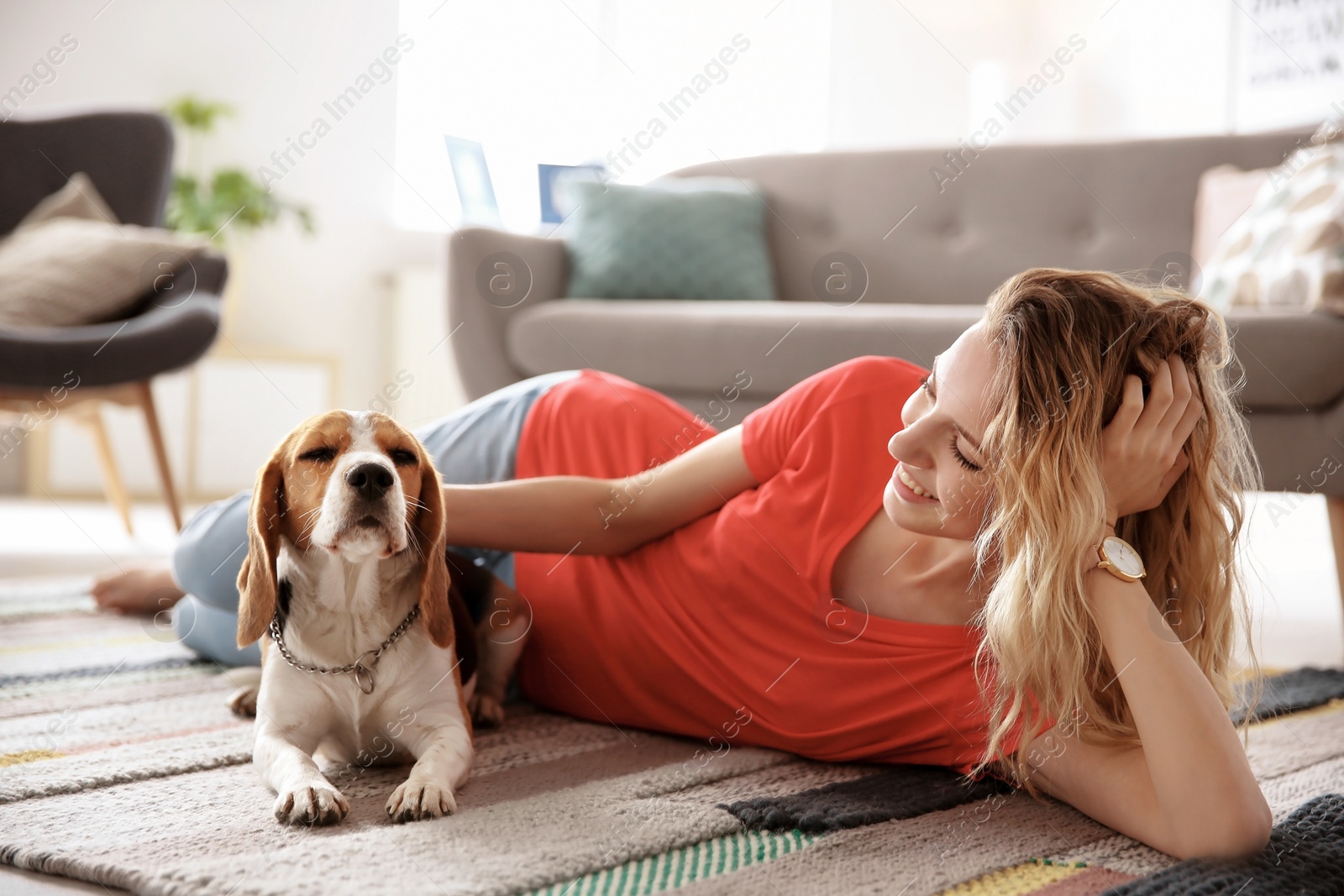 Photo of Young woman with her dog at home