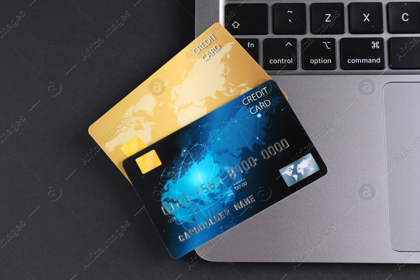 Photo of Credit cards and laptop on grey table, flat lay