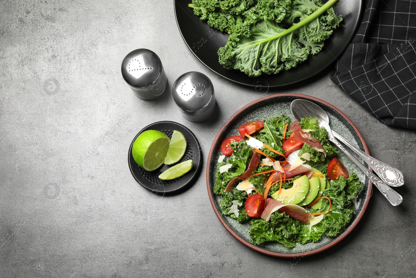 Photo of Delicious kale salad with prosciutto served on grey table, flat lay