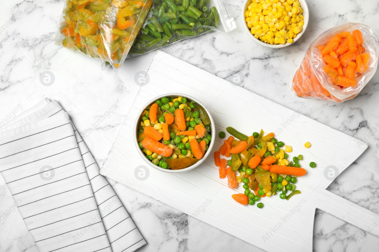 Photo of Flat lay composition with frozen vegetables on marble background