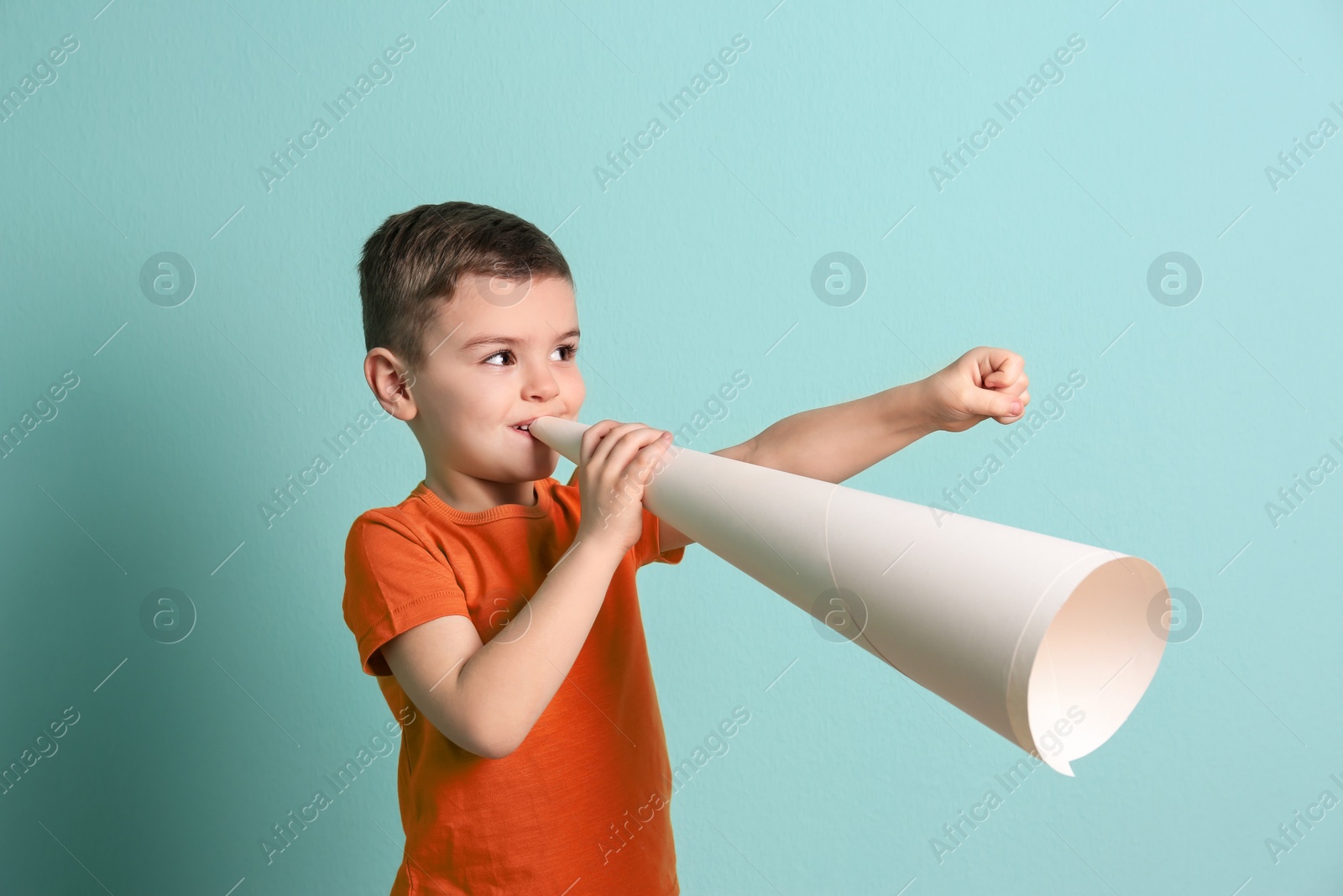 Photo of Adorable little boy with paper megaphone on color background