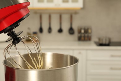 Photo of Modern stand mixer with cream in kitchen, closeup. Space for text