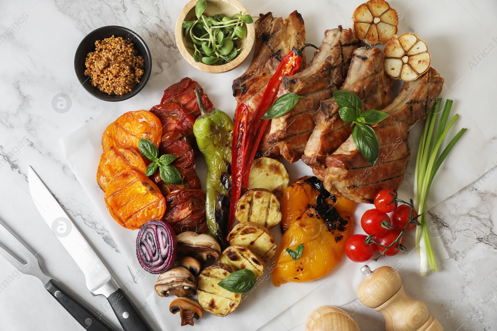 Photo of Delicious grilled meat and vegetables served on white marble table, flat lay