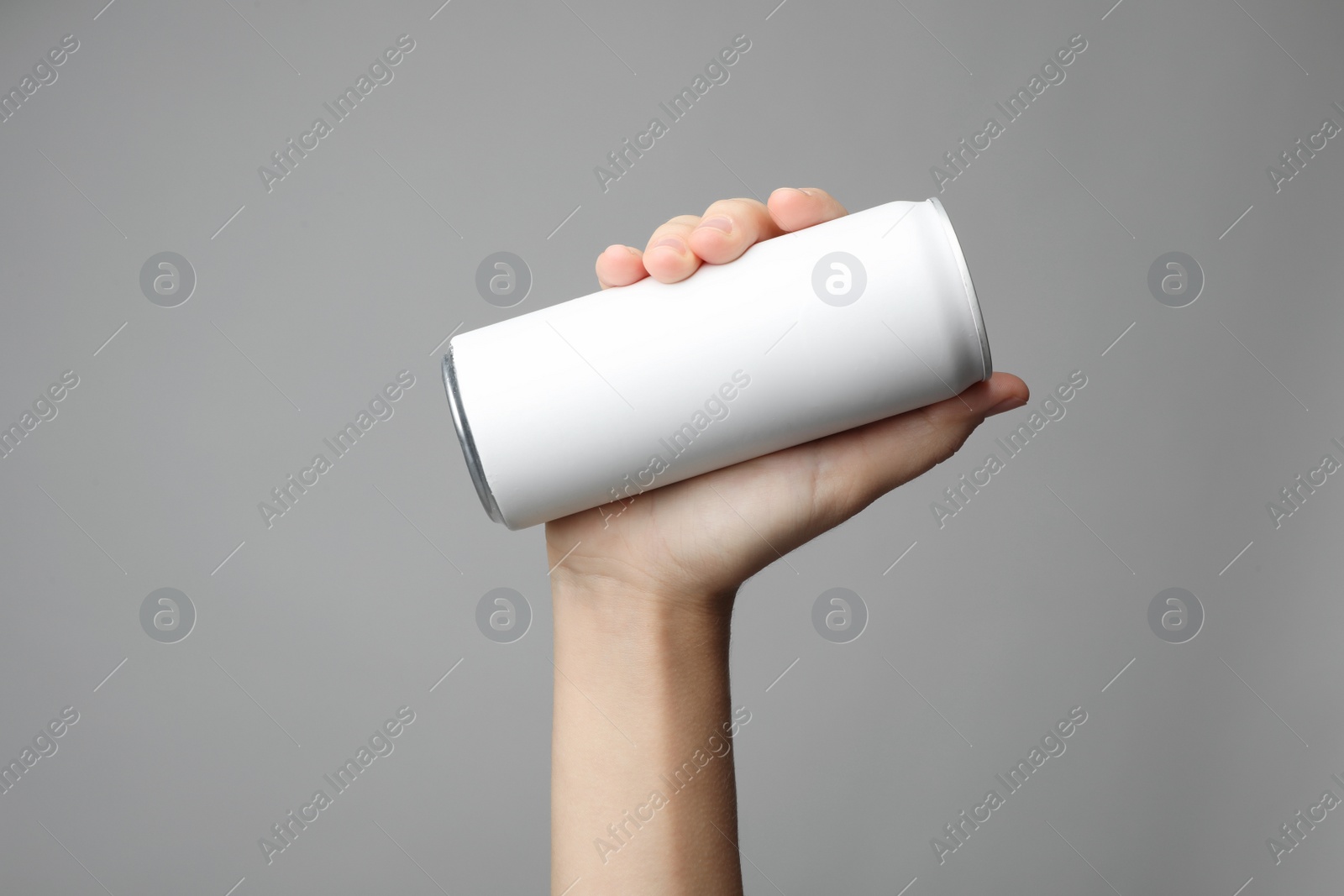 Photo of Woman holding aluminum can with beverage on grey background, closeup. Space for design