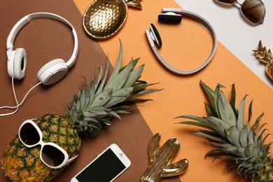 Photo of Flat lay composition with pineapples, headphones and smart phone on color background