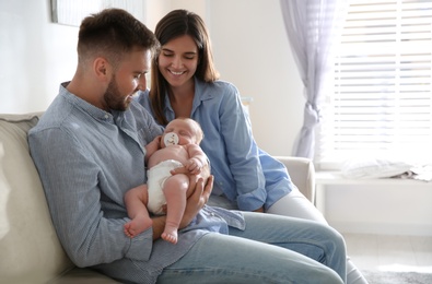 Photo of Happy couple with their newborn baby at home