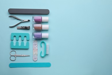 Set of pedicure tools on light blue background, flat lay. Space for text