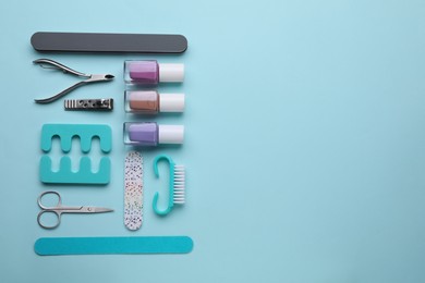 Photo of Set of pedicure tools on light blue background, flat lay. Space for text