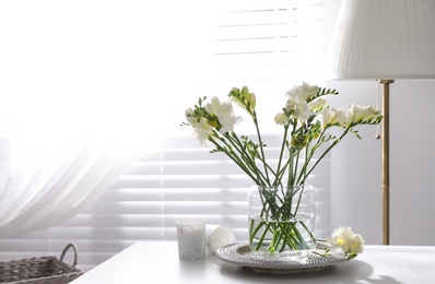 Photo of Beautiful spring freesia flowers on table in room