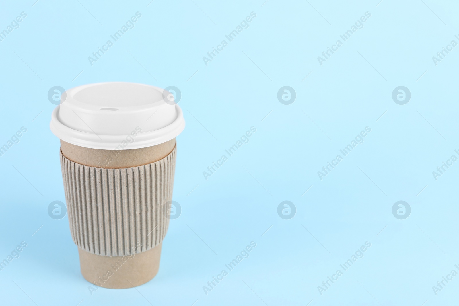 Photo of Paper cup with plastic lid on light blue background, space for text. Coffee to go