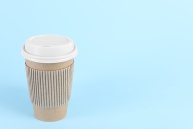 Photo of Paper cup with plastic lid on light blue background, space for text. Coffee to go