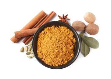 Dry curry powder in bowl and other spices isolated on white, top view