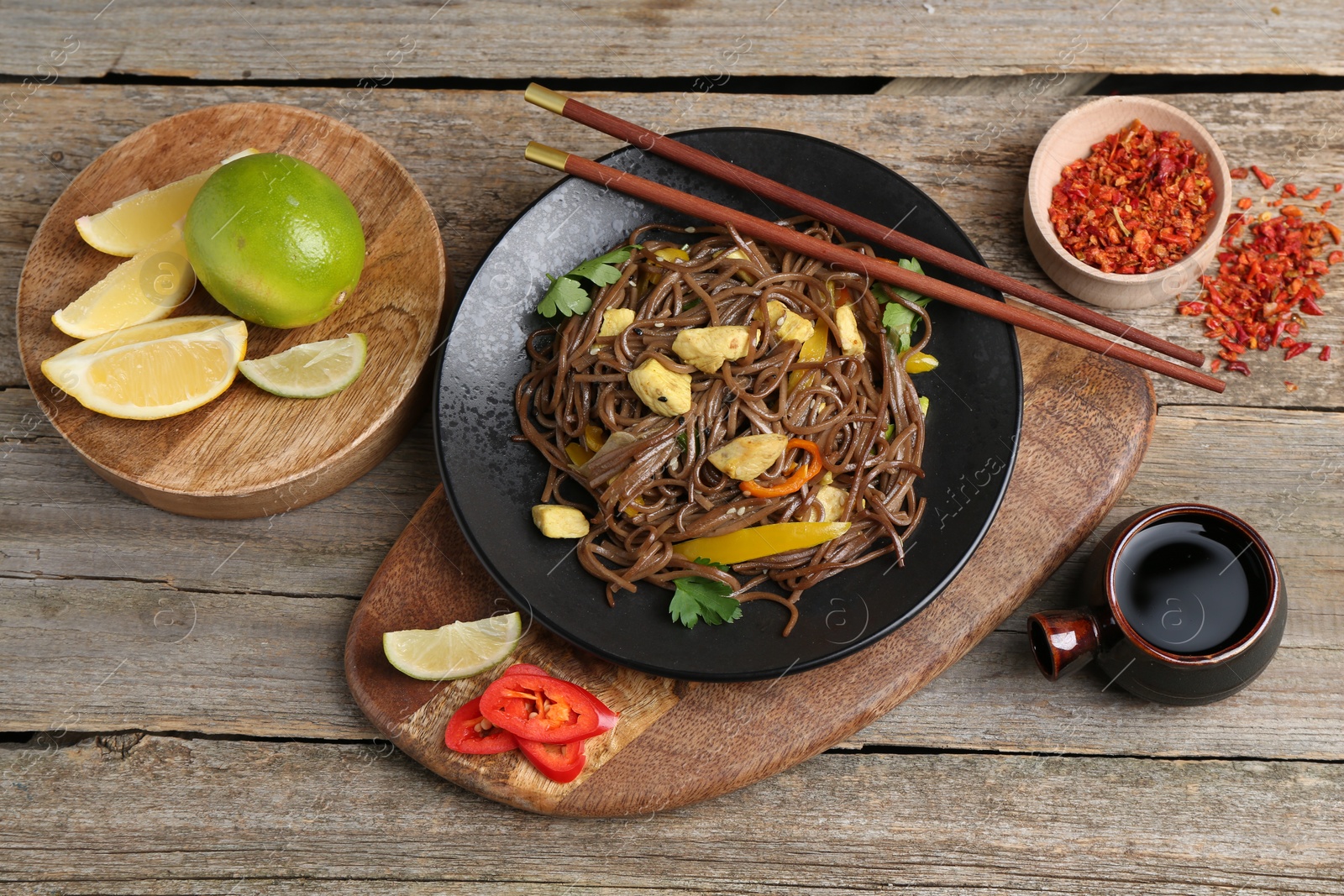 Photo of Stir-fry. Tasty noodles with vegetables and meat served on wooden table, flat lay