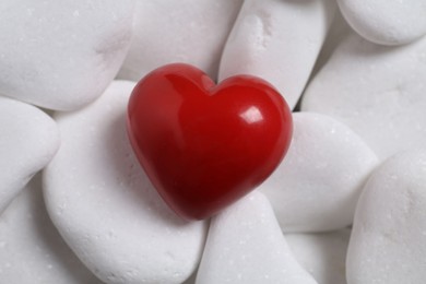 Photo of Decorative heart on white pebble stones, above view