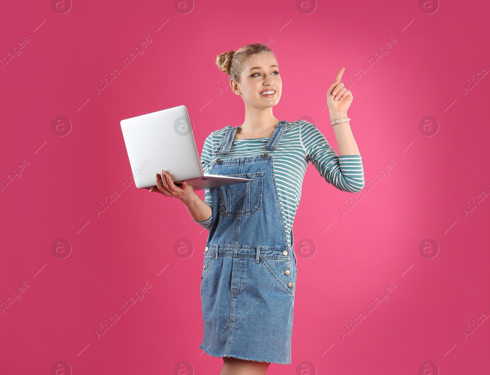 Photo of Portrait of young woman with laptop on pink background