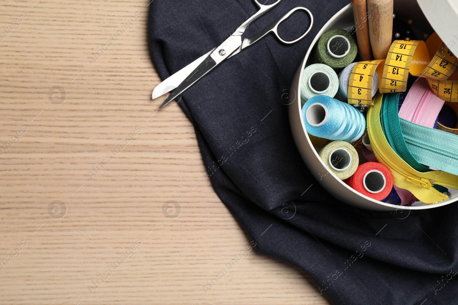 Photo of Flat lay composition with different sewing accessories on wooden background. Space for text