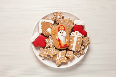 Tasty gingerbread cookies on white wooden table, top view. St. Nicholas Day celebration