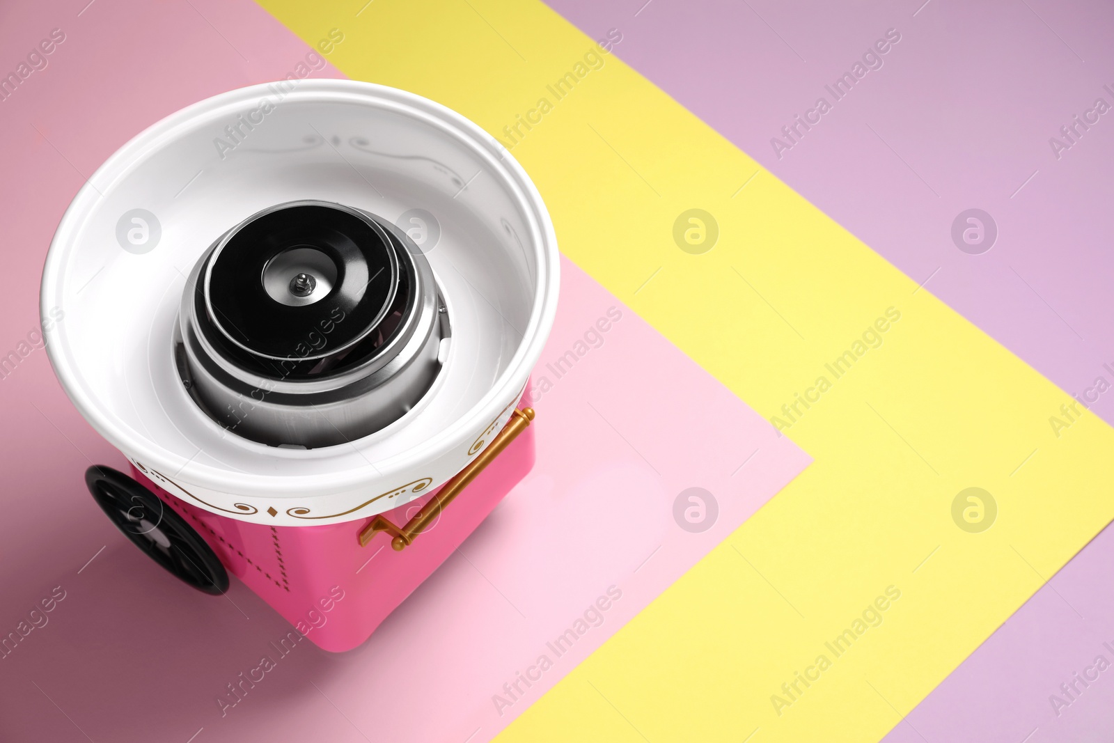 Photo of Portable candy cotton machine on color background, above view. Space for text