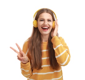 Young woman listening to music with headphones on white background