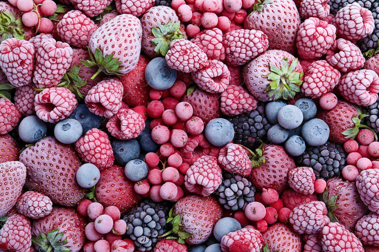 Photo of Mix of different frozen berries as background, top view