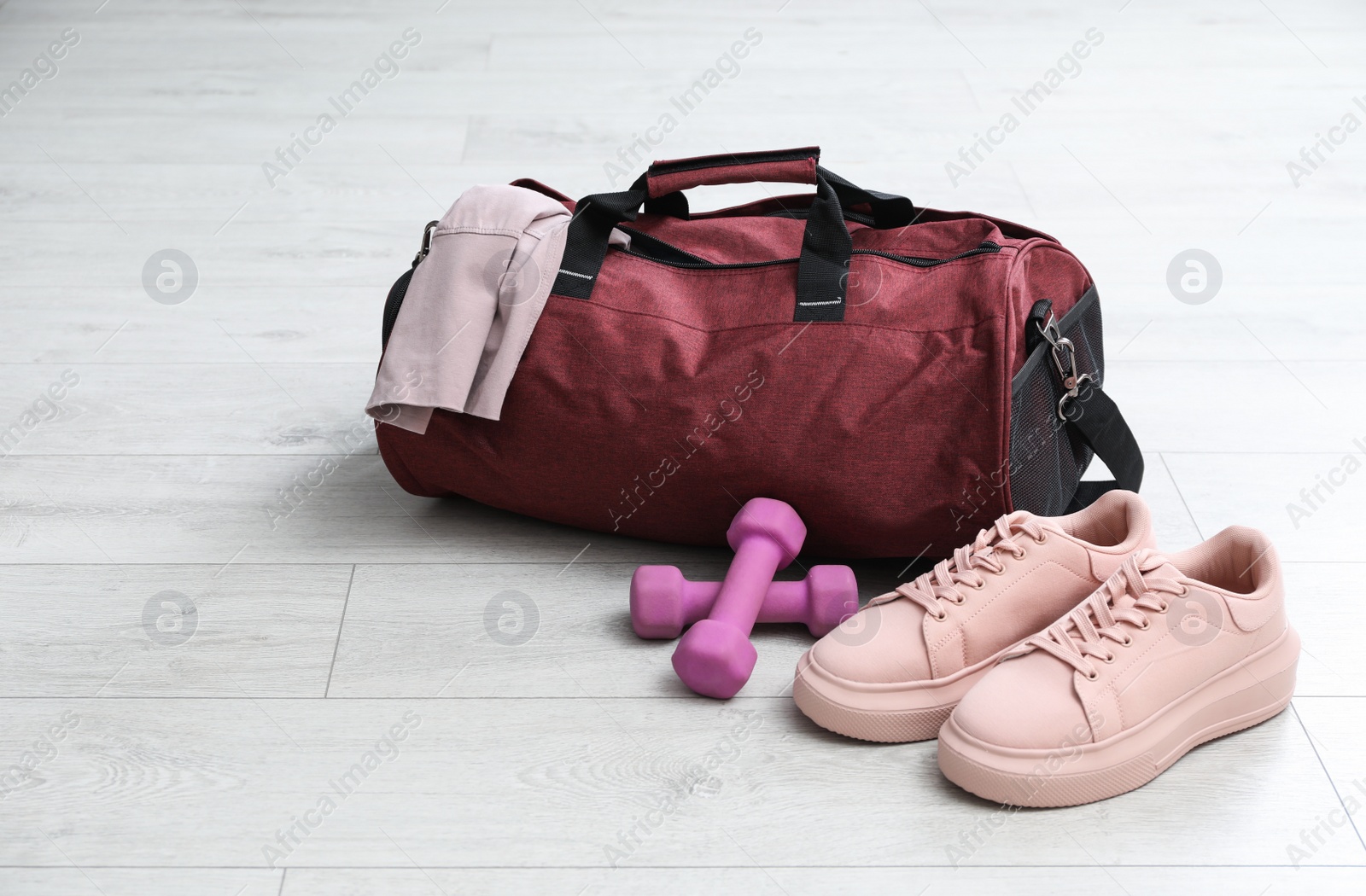 Photo of Sports bag and gym stuff on white floor