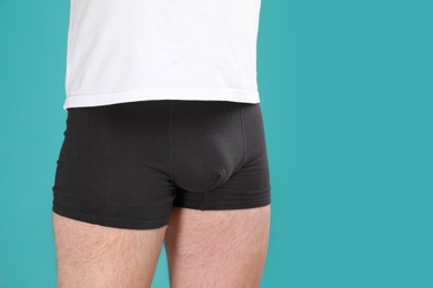 Photo of Man in underwear on turquoise background, closeup. Urology problems