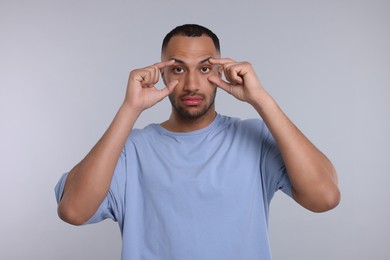 Photo of Tired man on light grey background. Insomnia problem