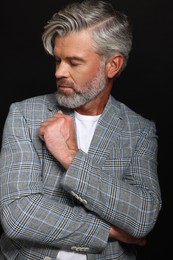 Photo of Portrait of confident man with beautiful hairstyle on black background