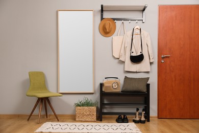 Photo of Modern hallway interior with stylish chair, shoe rack and mirror