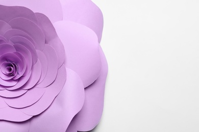 Photo of Beautiful violet flower made of paper on white background, top view