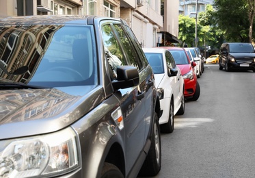 Photo of City street with row of modern cars