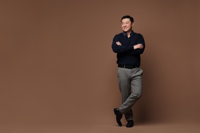 Photo of Full length portrait of happy man on brown background. Space for text