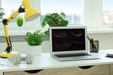 Photo of Cozy workspace with laptop on white wooden desk at home