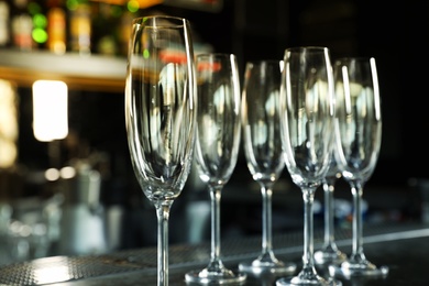 Photo of Empty clean champagne glasses on counter in bar