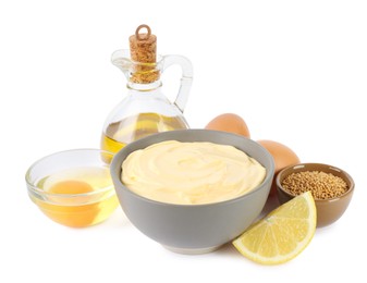 Photo of Bowl with fresh mayonnaise and ingredients on white background