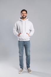 Photo of Full length portrait of young man in sweater on grey background. Mock up for design