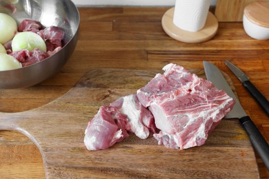 Photo of Fresh raw meat and ripe onions on wooden table